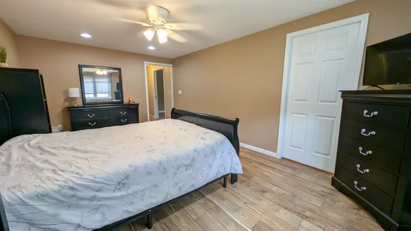 a bedroom with a bed and a flat tv screen on dresser
