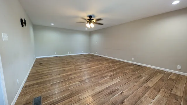 wooden floor in an empty room with a window