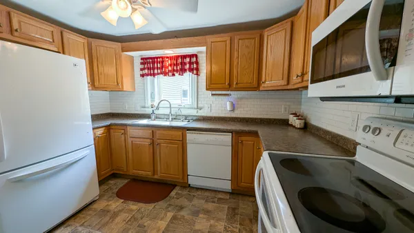 a kitchen with stainless steel appliances granite countertop a sink a stove and a microwave