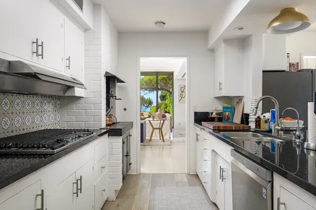 a kitchen with a sink a stove and cabinets