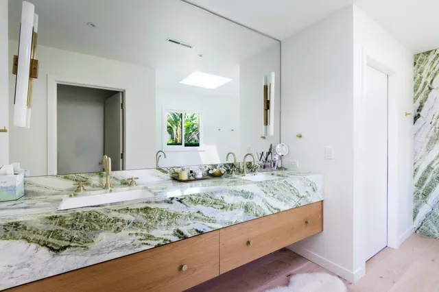 a bathroom with a granite countertop sink and a mirror