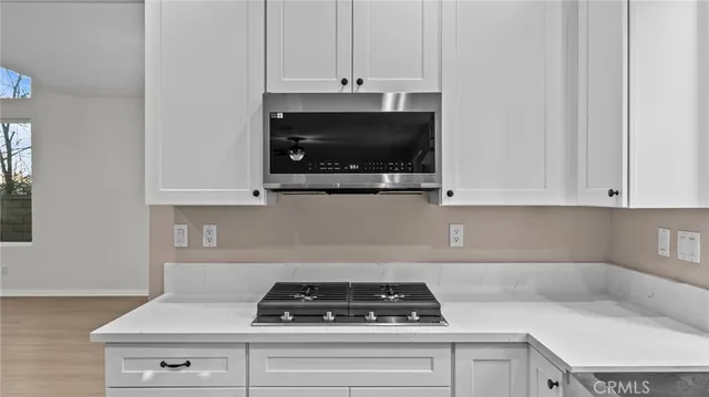 a kitchen with white cabinets and a stove top oven