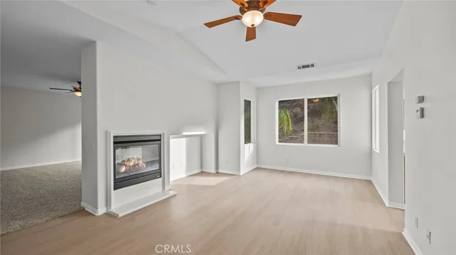 an empty room with windows and fireplace