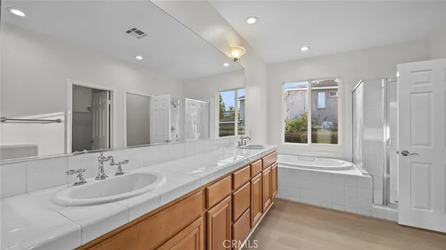 a bathroom with a granite countertop sink and a bathtub