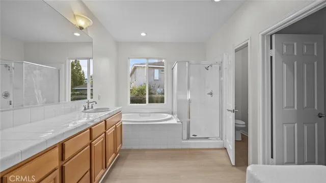 a bathroom with a granite countertop tub sink and mirror
