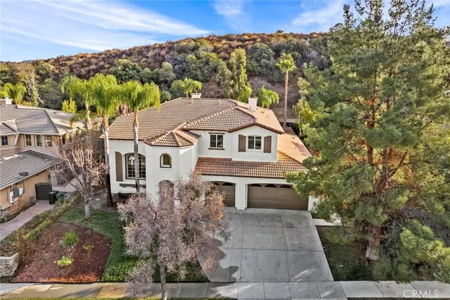 a aerial view of a house with a yard and large trees