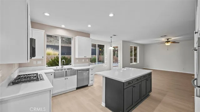 a large white kitchen with a stove and a sink
