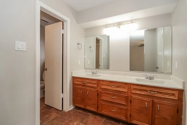 a bathroom with a granite countertop double vanity sink mirror and