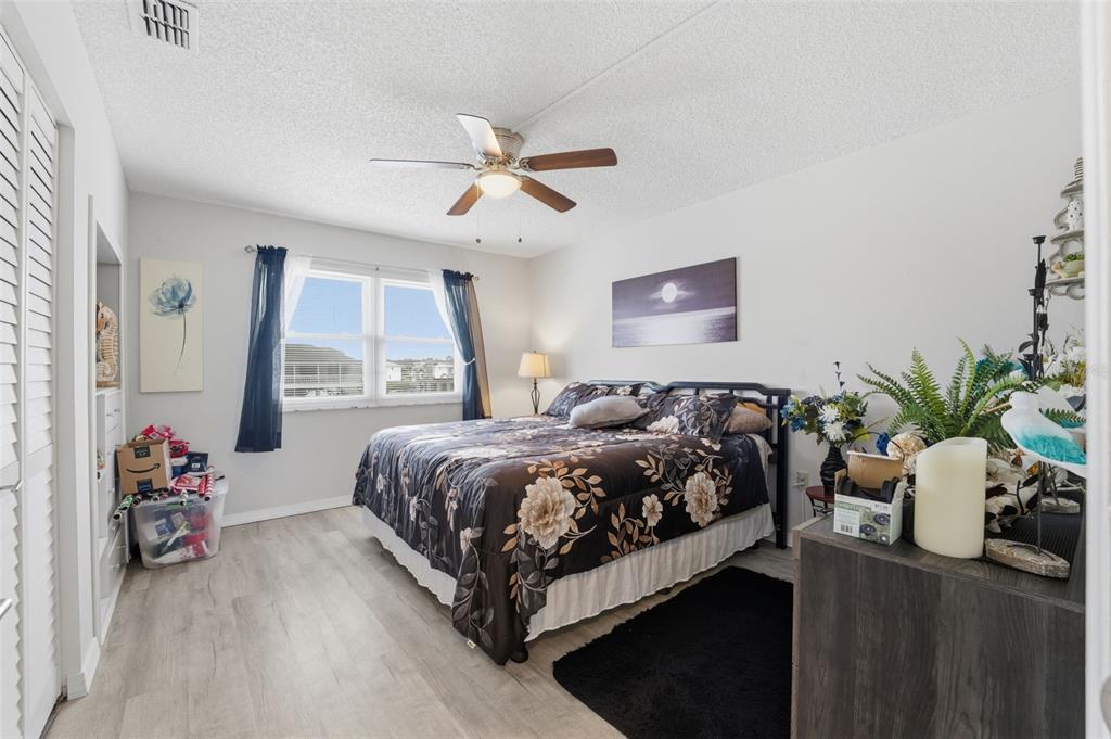 3366 Bluefish Drive Hernando Beach, FL 34607 - Photo 17 of 75 a bed sitting in a bedroom next to a window with a potted plant on a dresser