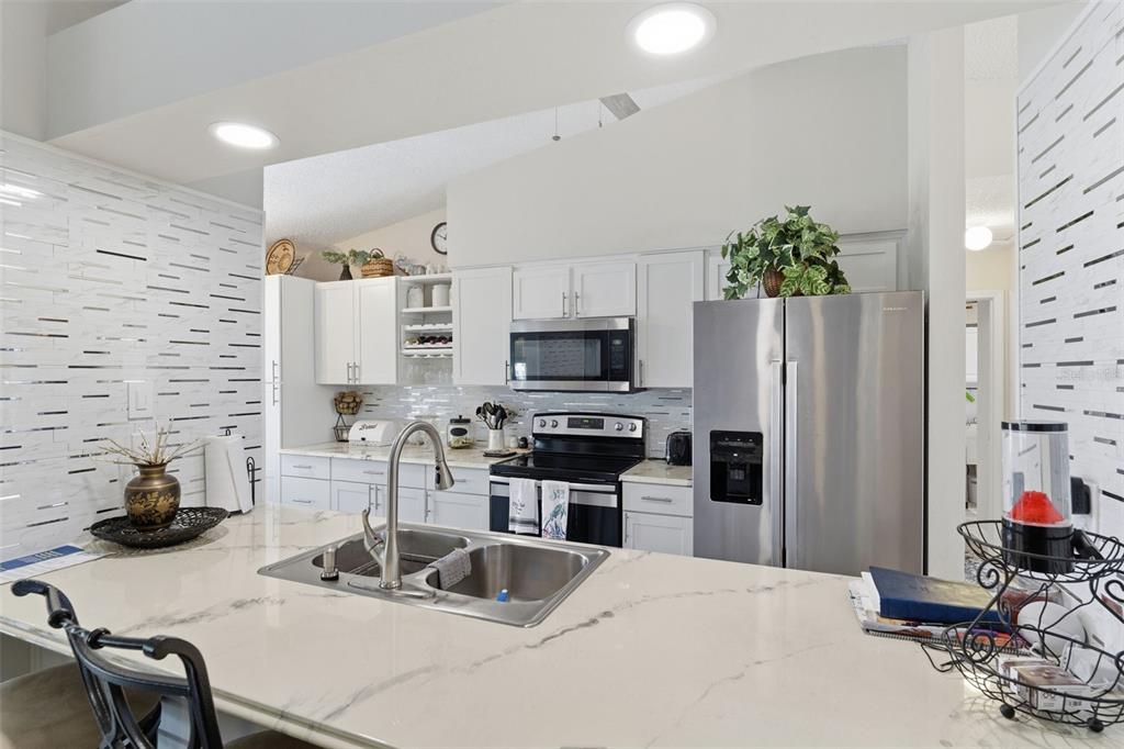 3366 Bluefish Drive Hernando Beach, FL 34607 - Photo 9 of 75 a kitchen with stainless steel appliances a sink a stove a refrigerator cabinets and a dining table