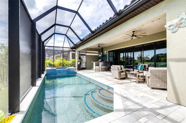 a view of swimming pool with outdoor seating and a patio
