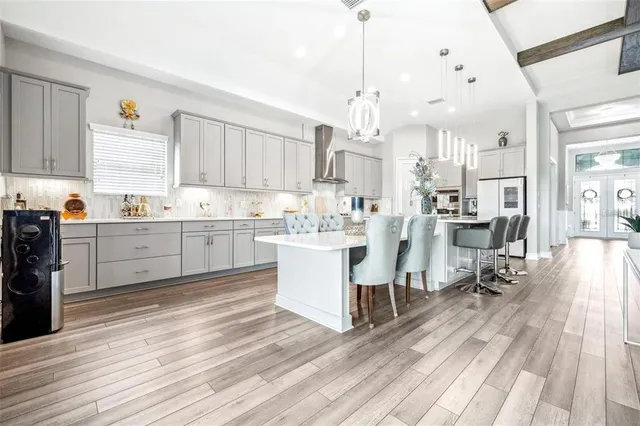 a kitchen with stainless steel appliances kitchen island wooden floors and white cabinets