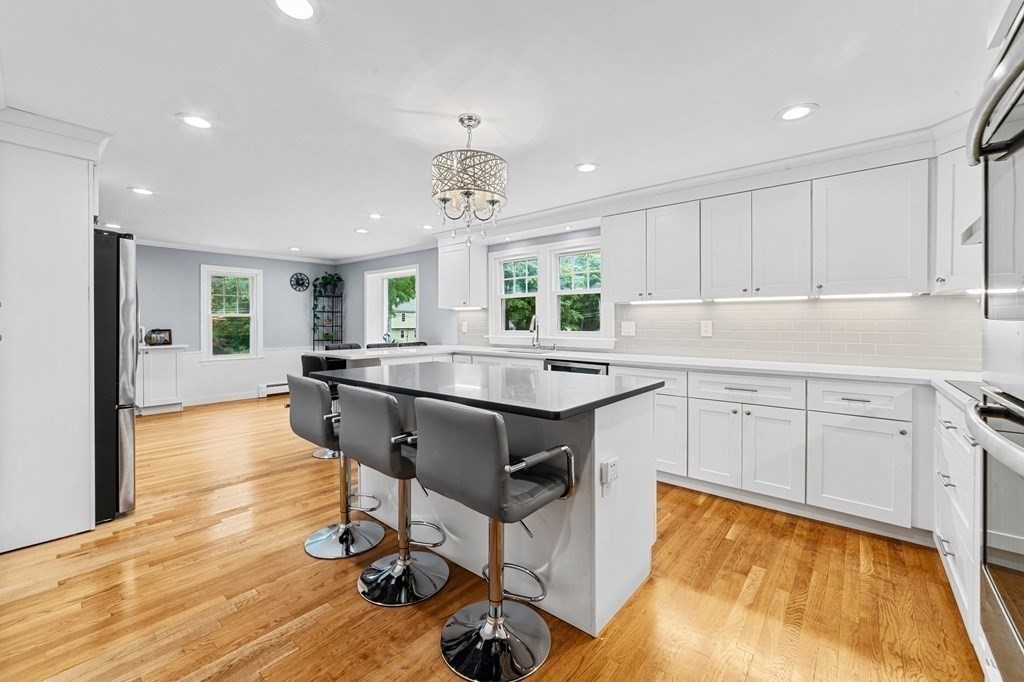 21 Olde Lantern Road Acton, MA 01720 - Photo 5 of 41 a kitchen with kitchen island granite countertop a sink counter and chairs