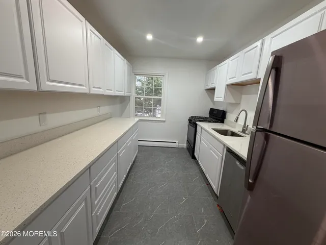 a kitchen with white cabinets and white appliances