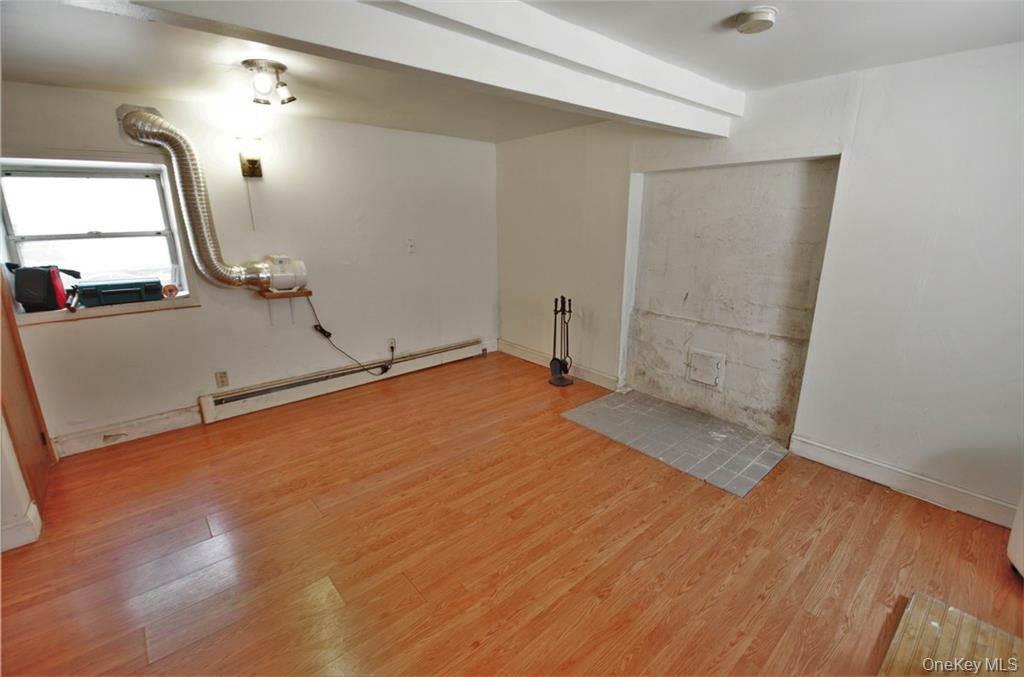 16 Woodland Road Middletown, NY 10940 - Photo 11 of 13 an empty room with wooden floor and mirror
