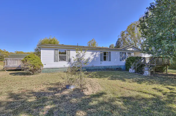 a view of a yard in front of a house with large tree
