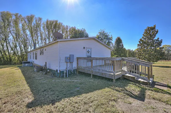 a view of a house with a yard and a wooden deck