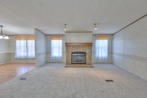 an empty room with windows and fireplace