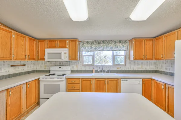 a kitchen with a sink a stove cabinets and a counter top space
