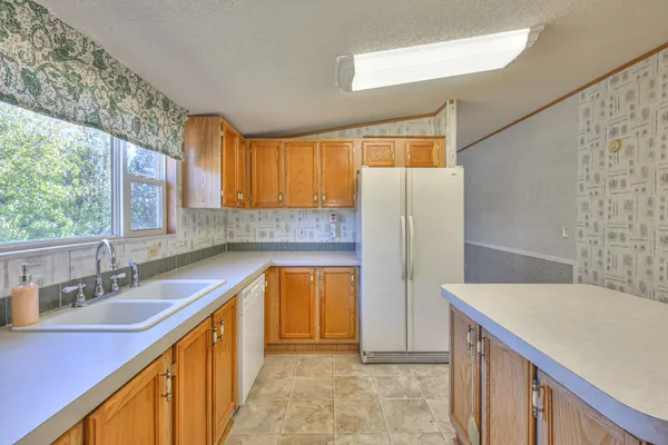 a kitchen with a sink a refrigerator and a window