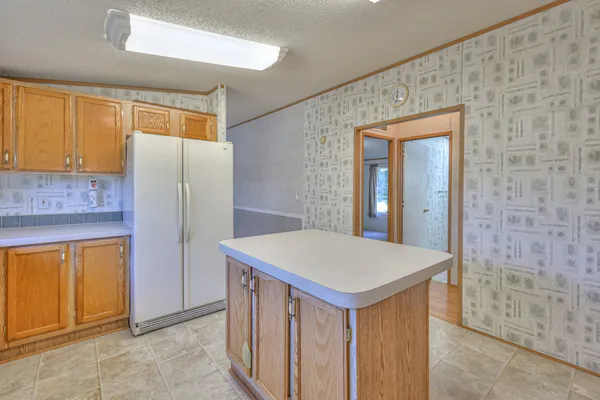 a kitchen with a refrigerator a table and chairs