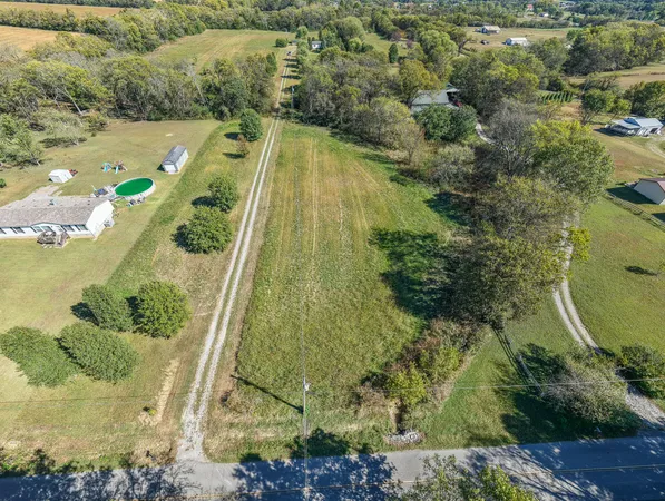a aerial view of a house with a yard and large trees