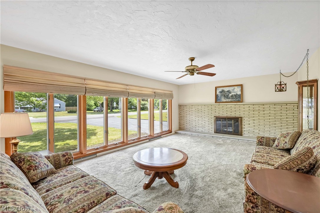3690 Long Road Avon, OH 44011 - Photo 2 of 41 Living room with carpet flooring, a brick fireplace, and ceiling fan