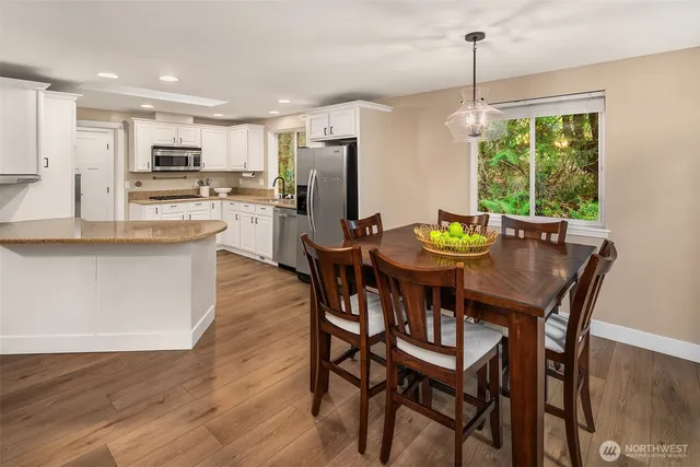 a view of a dining room and a kitchen with a table chairs