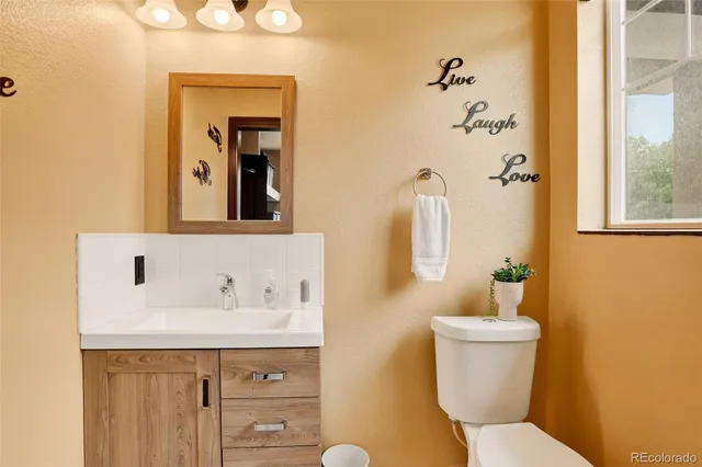a bathroom with a sink mirror and toilet