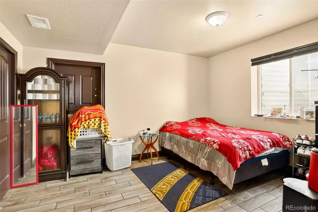 a bedroom with a bed a dresser and window