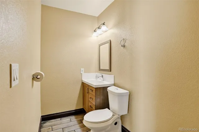 a bathroom with a toilet a sink and mirror