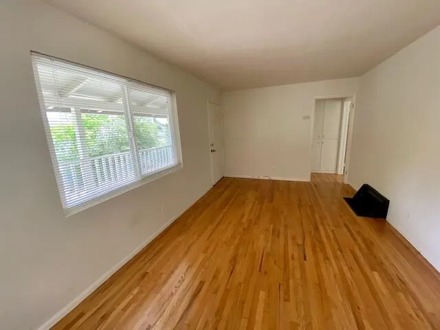a big room with wooden floor and a window