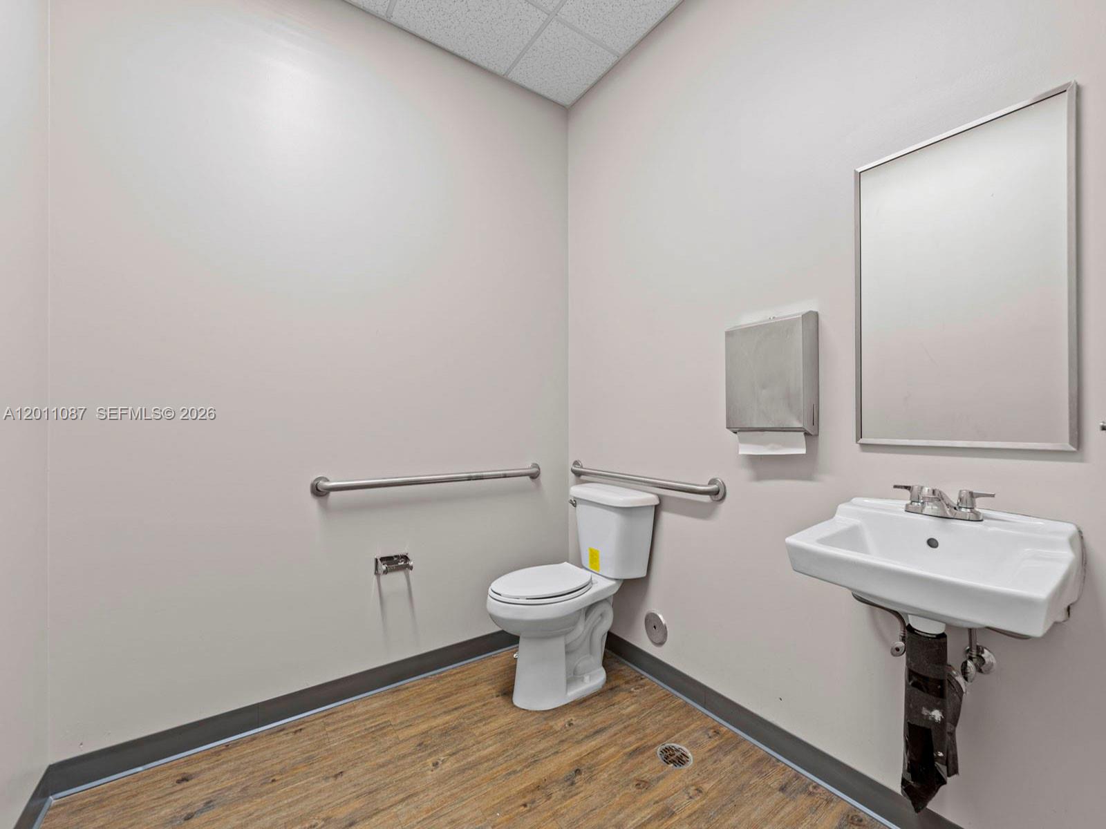 735 Shotgun Road Sunrise, FL 33326 - Photo 17 of 21 a bathroom with a sink a toilet and a mirror