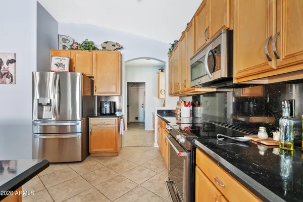 a kitchen with stainless steel appliances granite countertop a refrigerator a stove and a sink