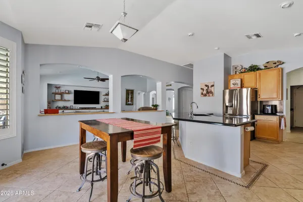 a kitchen with stainless steel appliances kitchen island granite countertop a table and chairs in it