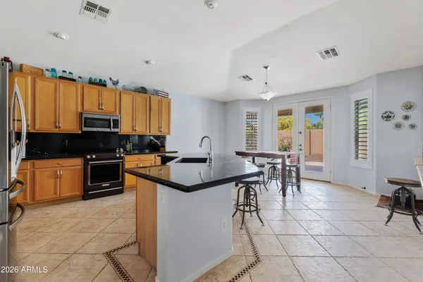 a kitchen with stainless steel appliances granite countertop a stove a sink and a refrigerator