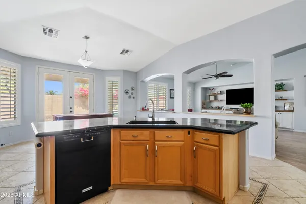 a kitchen with granite countertop cabinets a sink a window and stainless steel appliances