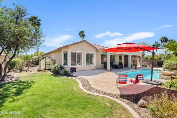 a view of a house with backyard and sitting area