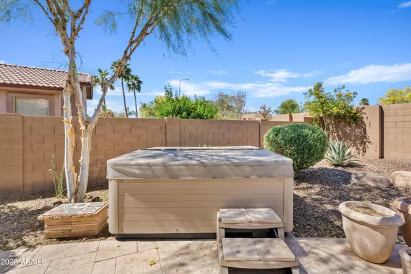 a view of a patio with couple of cars parked in front of house