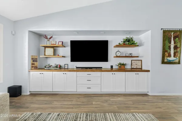 a kitchen with stainless steel appliances cabinets and a flat screen tv