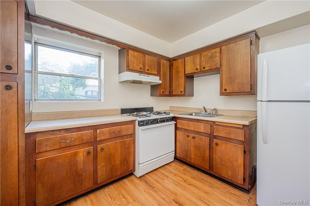 111 Kensington Road, Unit 8 Bronxville, NY 10708 - Photo 2 of 16 a kitchen with stainless steel appliances granite countertop a stove a sink dishwasher and a refrigerator