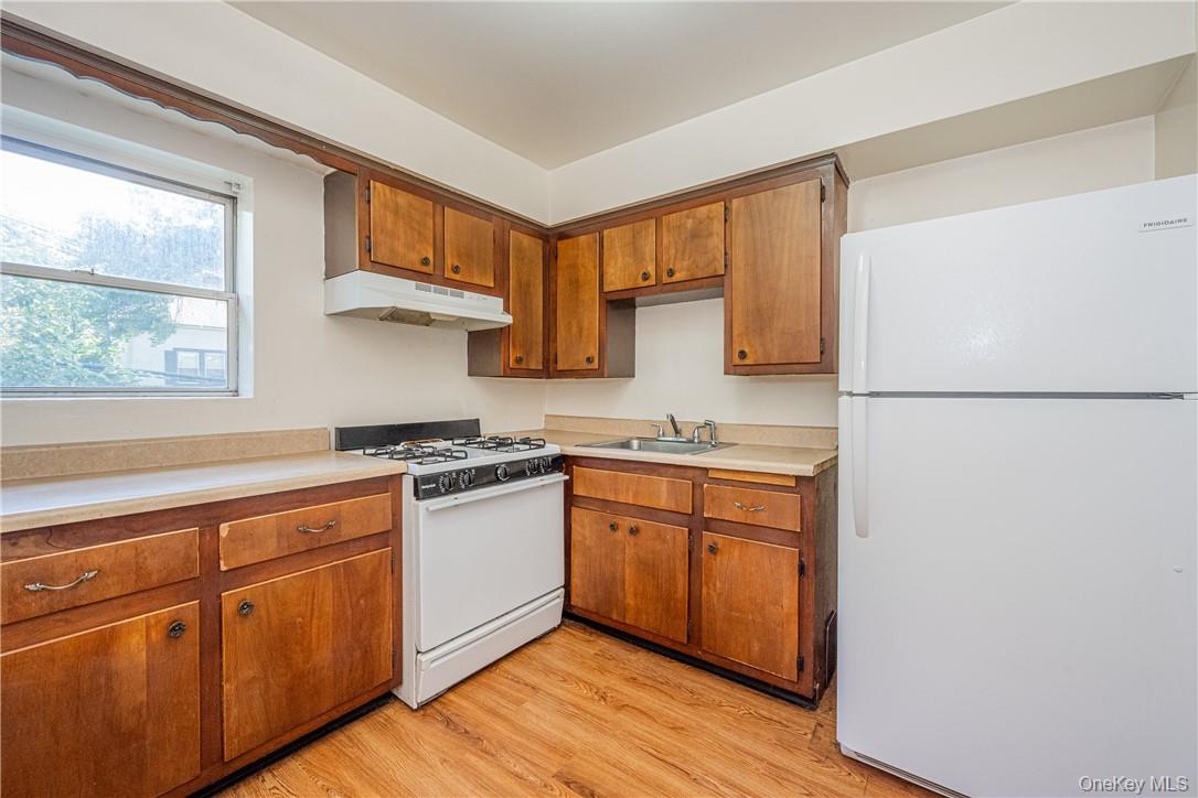 111 Kensington Road, Unit 8 Bronxville, NY 10708 - Photo 3 of 16 a kitchen with stainless steel appliances granite countertop a refrigerator a stove a sink and a microwave