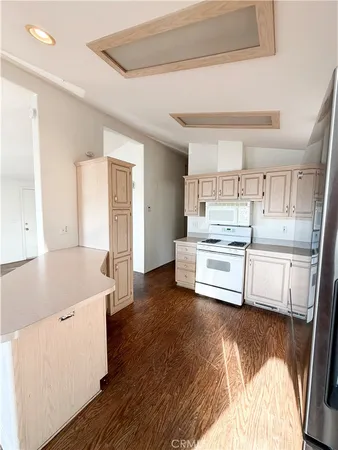 a kitchen with stainless steel appliances a white cabinets and wooden floor