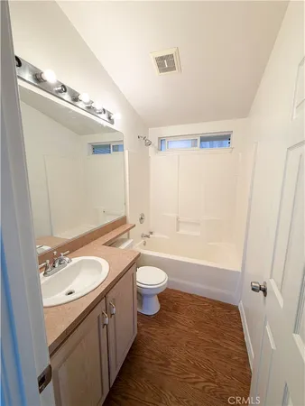 a bathroom with a granite countertop sink toilet a large mirror a shower and a bathtub
