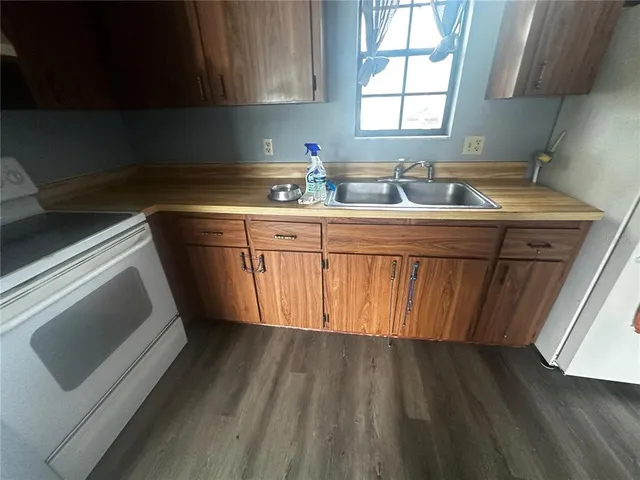 a kitchen with granite countertop wooden cabinets a sink and dishwasher