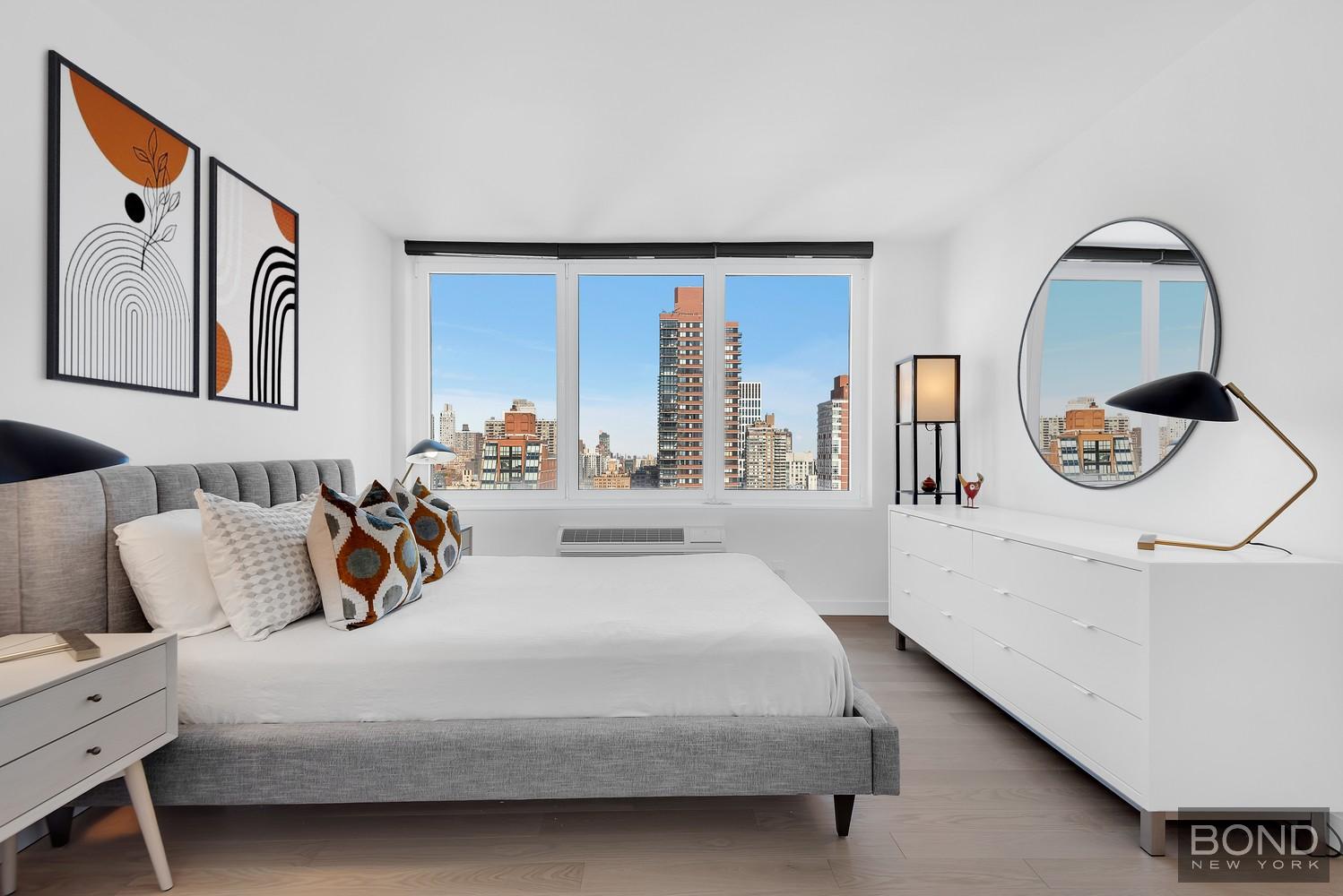 353 East 72nd Street, Unit 26A Manhattan, NY 10021 - Photo 4 of 8 a bedroom with a large bed and a large window