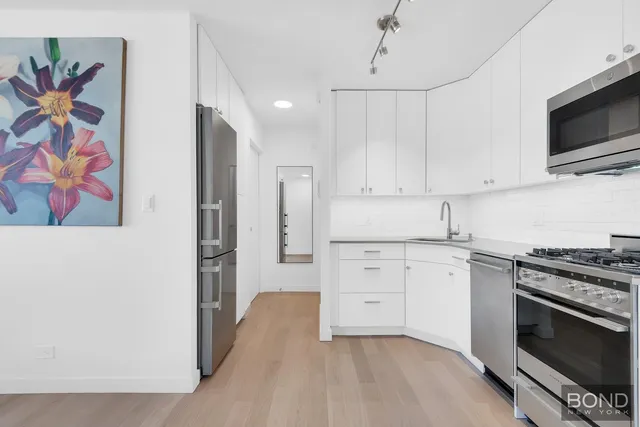 a kitchen with stainless steel appliances a stove a microwave and cabinets