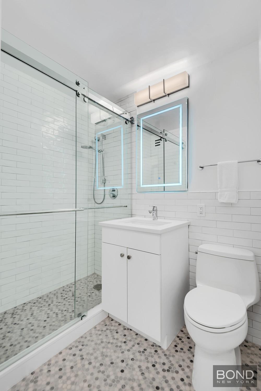 353 East 72nd Street, Unit 26A Manhattan, NY 10021 - Photo 6 of 8 a bathroom with a sink toilet and shower