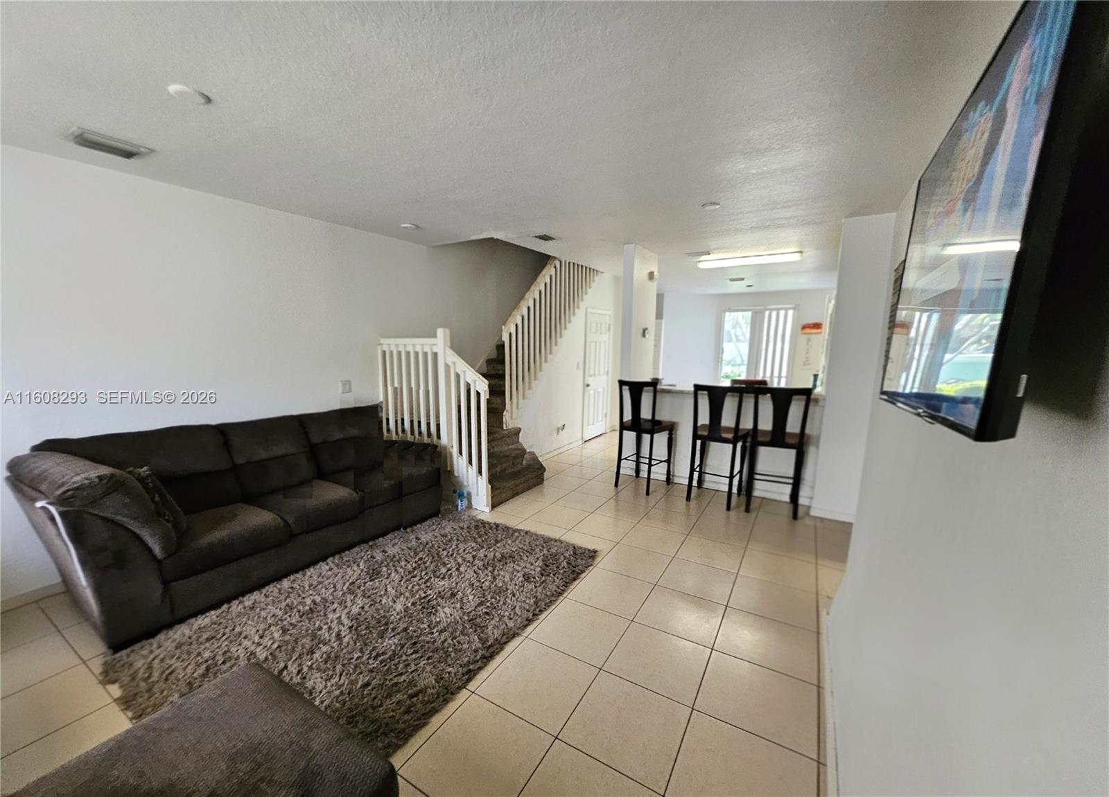 3556 Oleander Terrace, Unit 3556 Riviera Beach, FL 33404 - Photo 3 of 36 a living room with furniture and a dining table with kitchen view