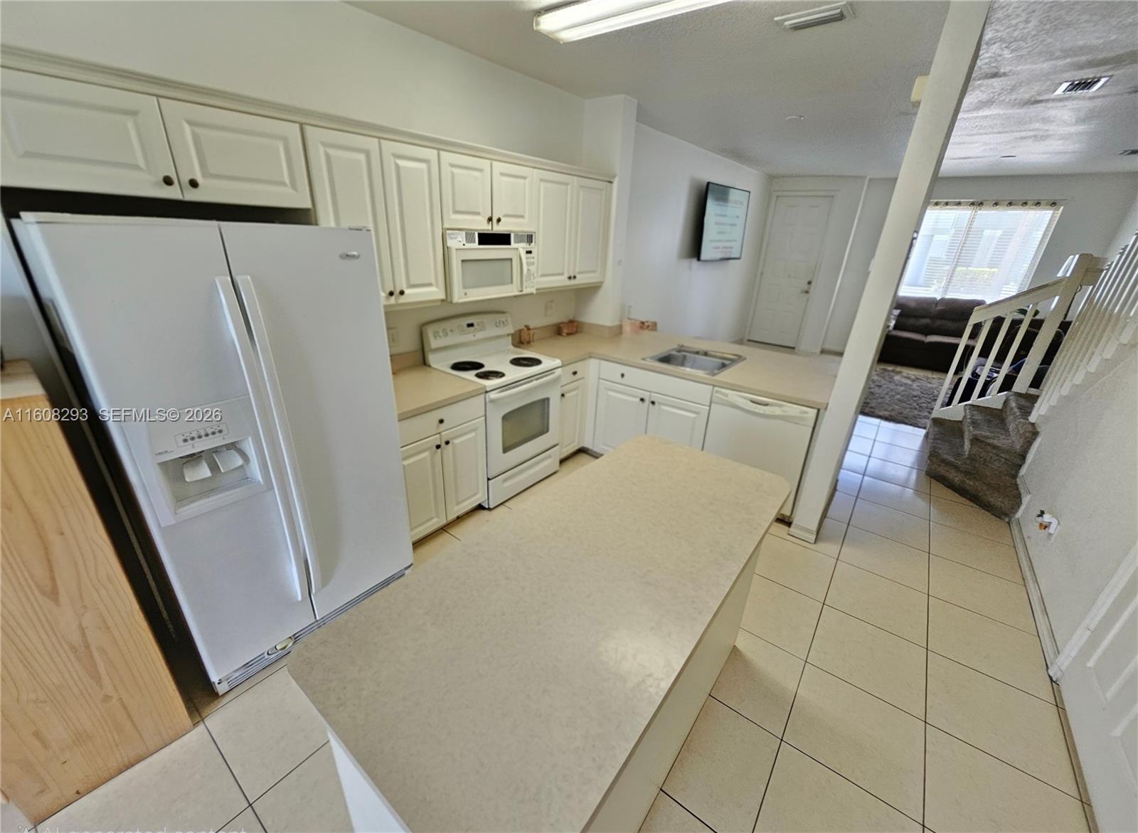 3556 Oleander Terrace, Unit 3556 Riviera Beach, FL 33404 - Photo 5 of 36 a kitchen with white cabinets and white appliances